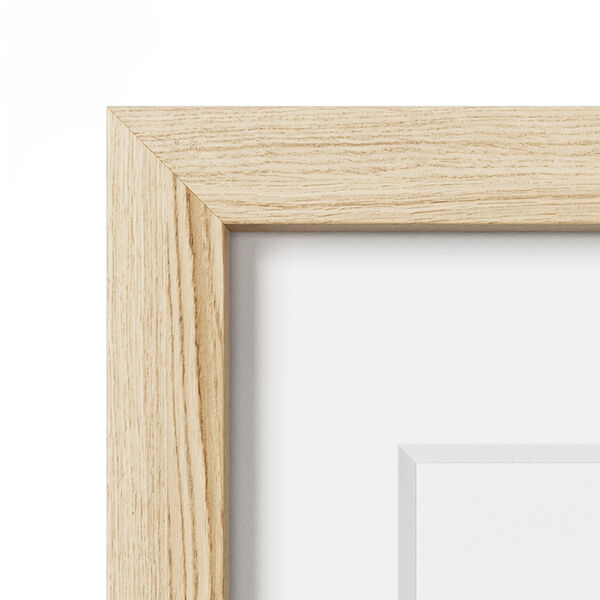 Corner of a natural oak frame with a white mat
